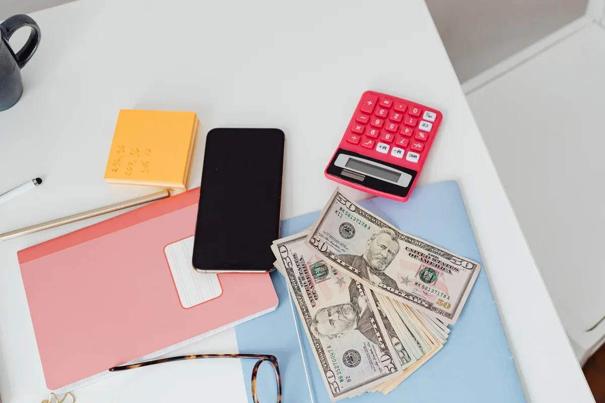 Counted US dollar bills and a calculator on a desk, the cash a forex position should be sized from